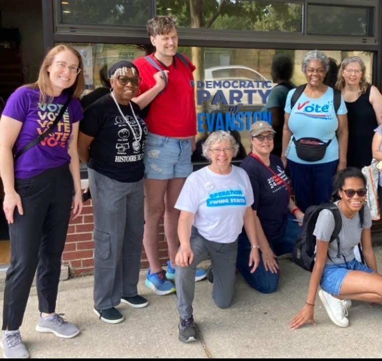 Nine DPOE volunteers in Vote and Operation Swing State T-shirts outside the Democratic Party of Evanston office.